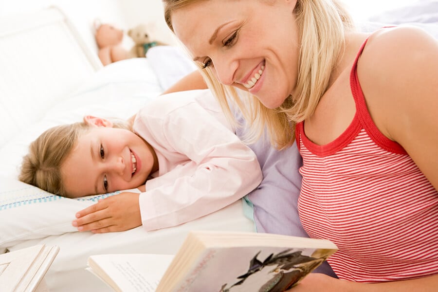 Mother reading a bedtime story to her young daughter